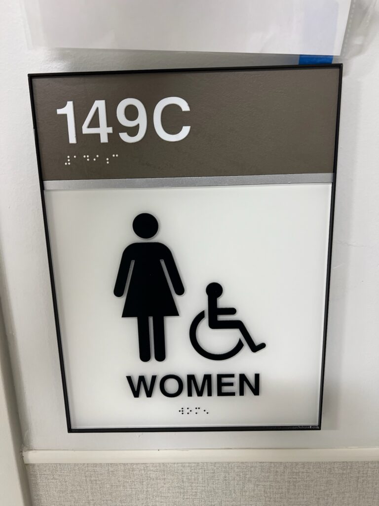 A handicap accessible room sign with braille. 